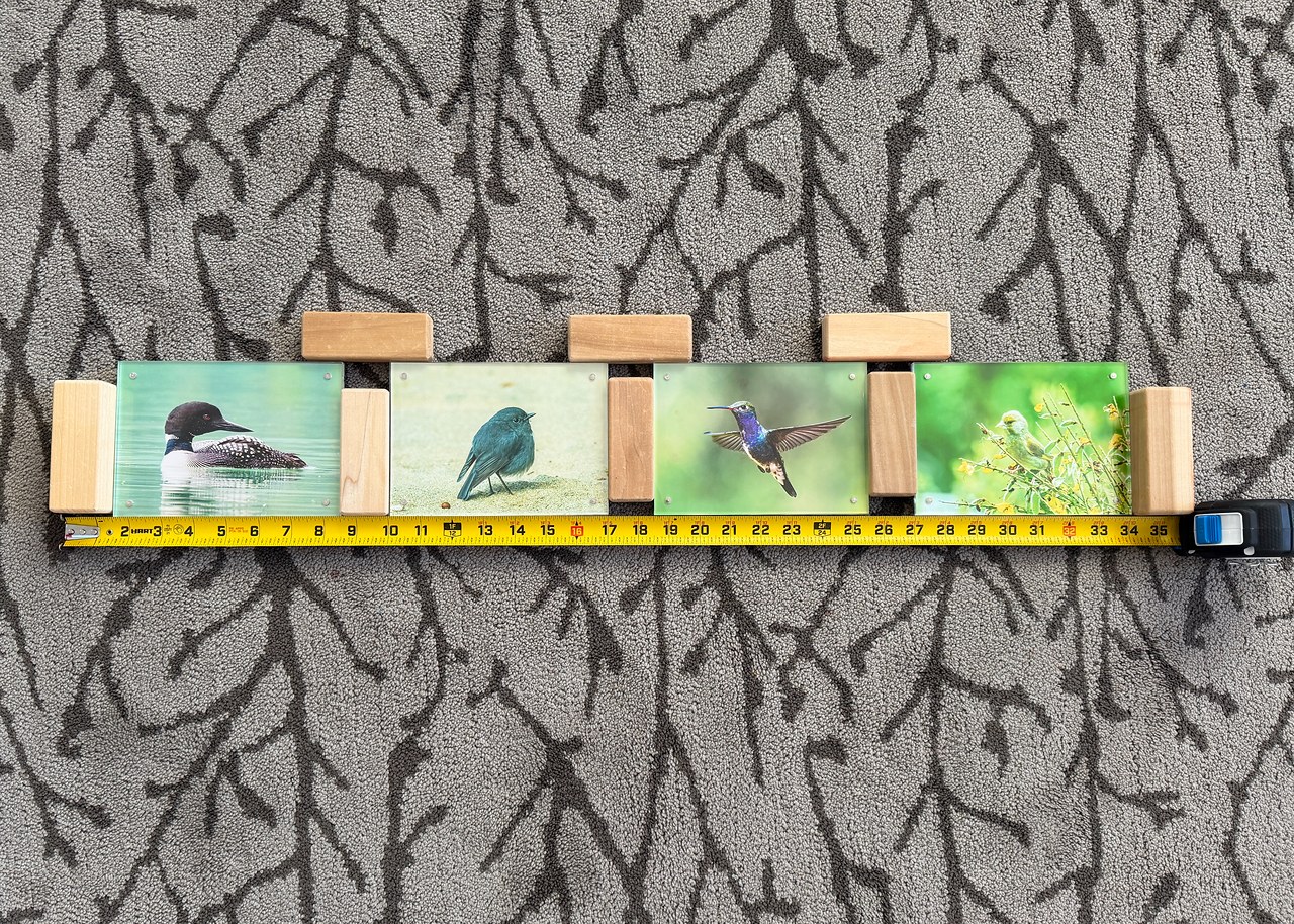 Photo frames arranged on the floor to test spacing and layout before mounting