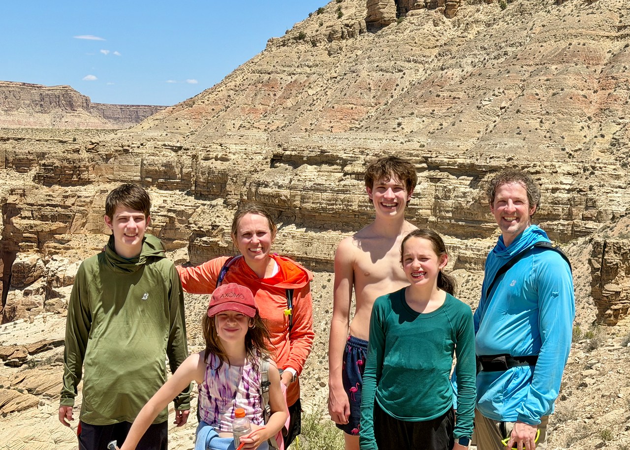 Family standing together at the Havasupai trailhead overlook after hiking out of the canyon.