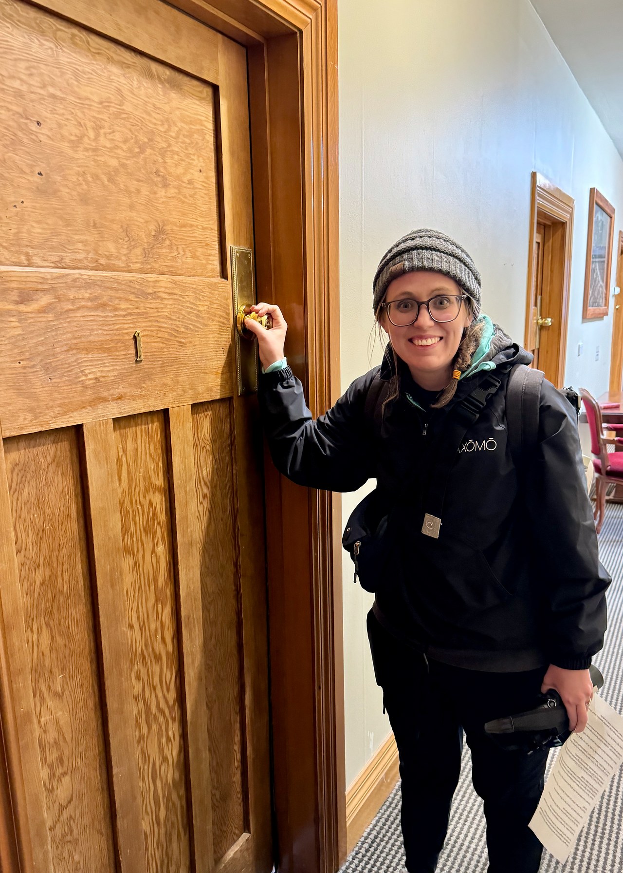 Stacy checking into a room at the Seaview Hotel on Stewart Island with an unusually high door knob
