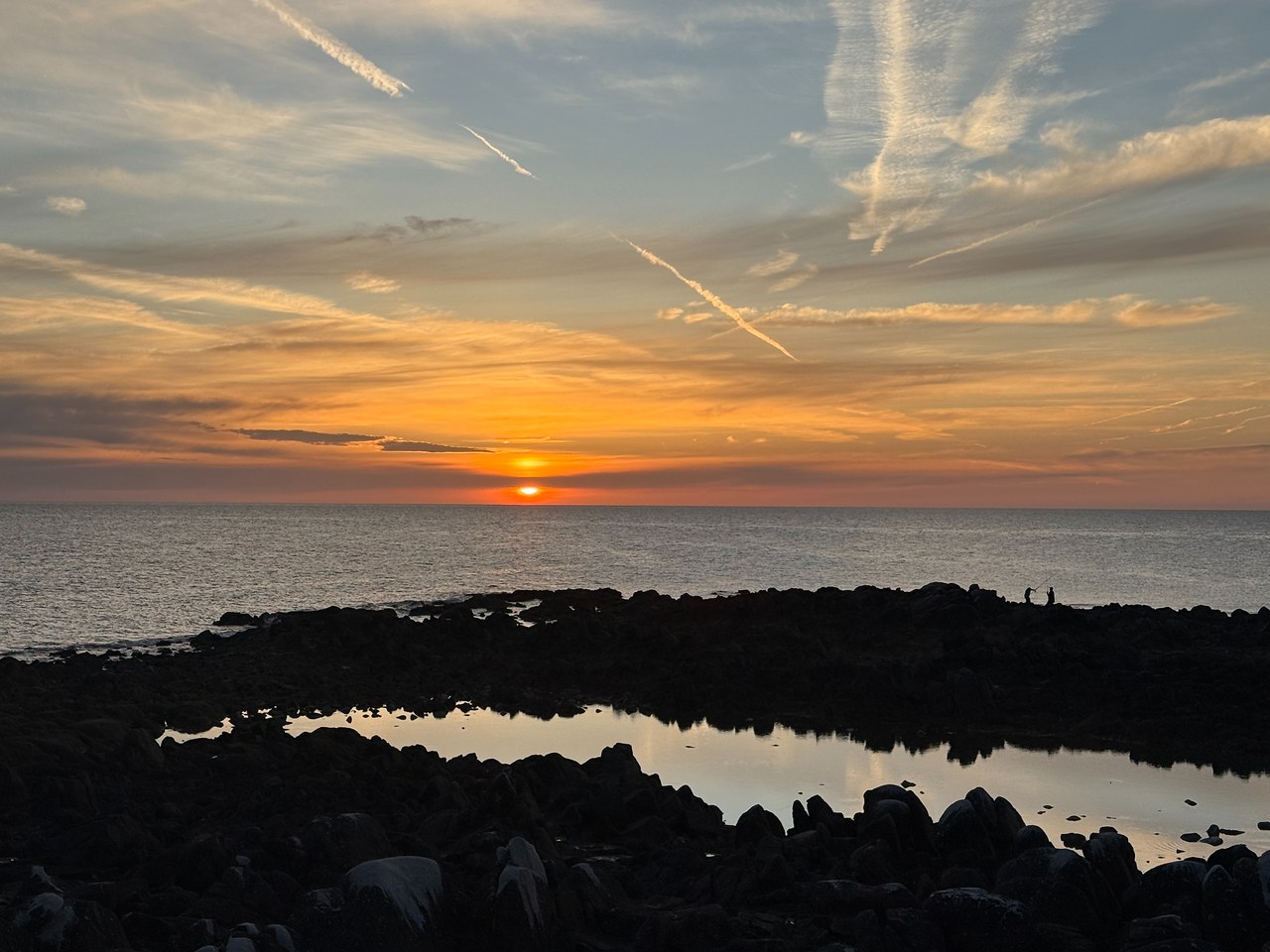 Sun setting over the Sea of Cortez beyond dark rocky tide pools near Puerto Peñasco