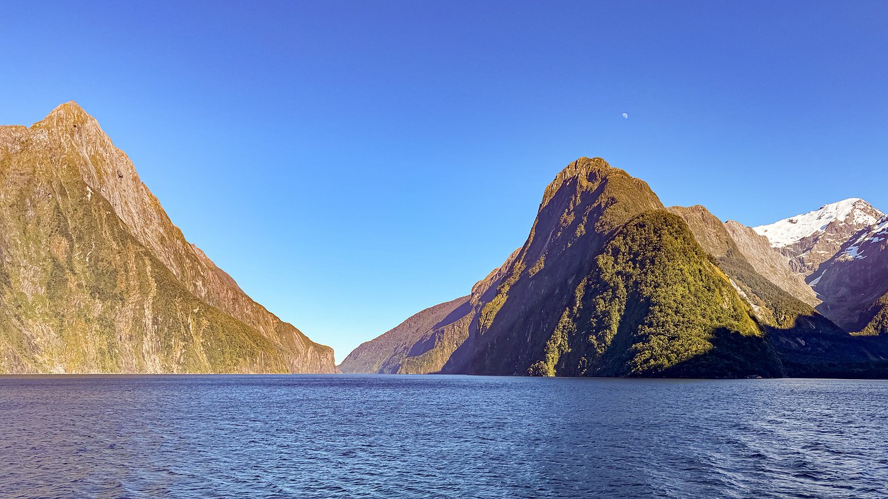 Wide view of Milford Sound with Mitre Peak rising above deep blue water