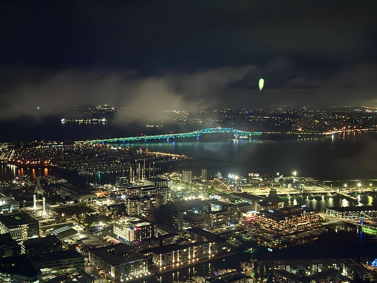 Auckland illuminated at night as seen from high inside the Sky Tower.