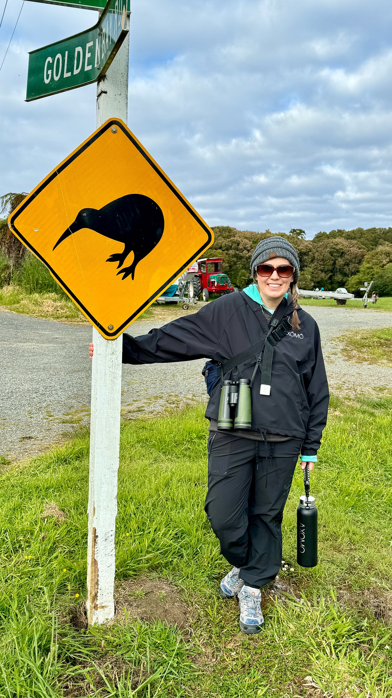 Stacy standing beside a kiwi crossing sign on Stewart Island