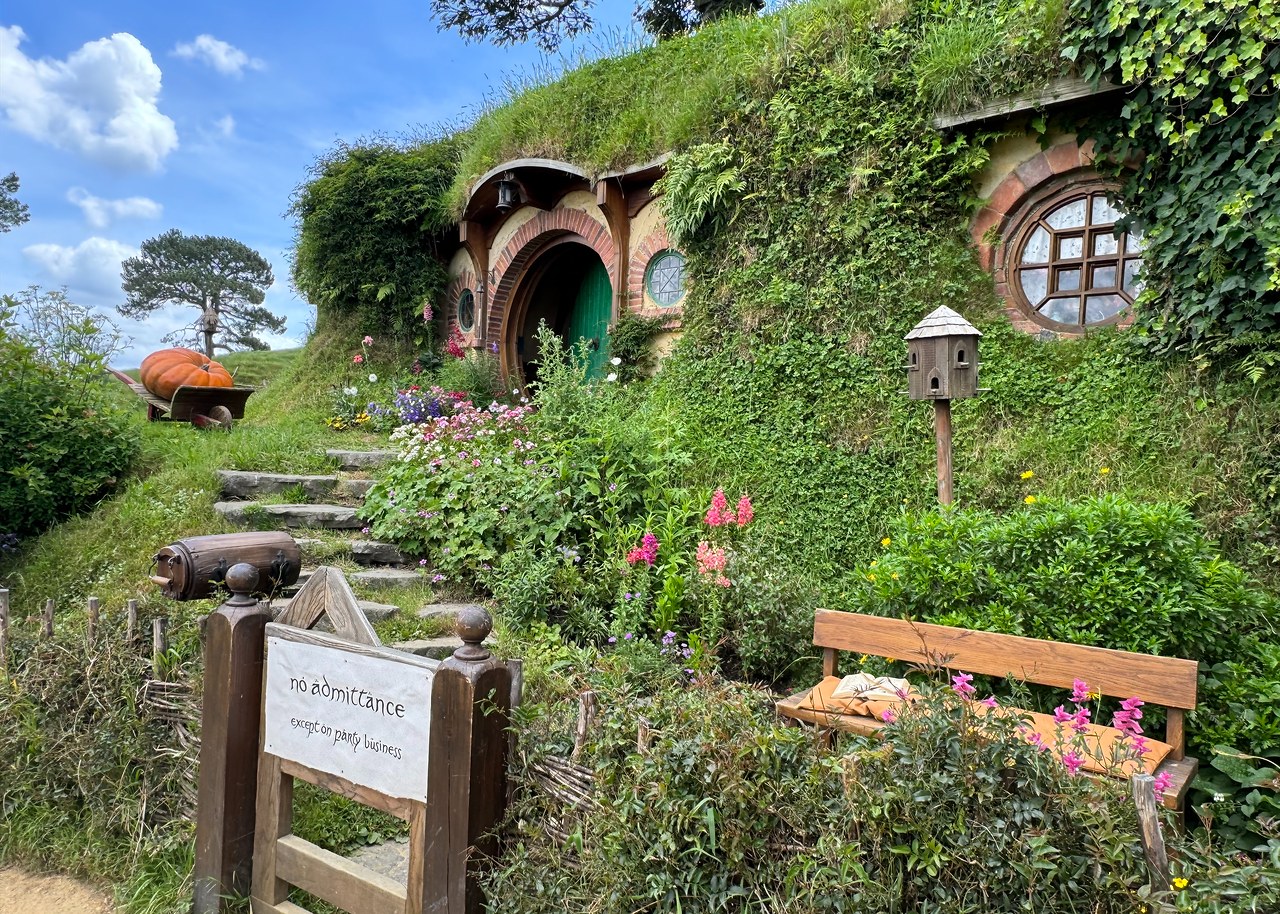 Bag End and its round green door set into the hillside at Hobbiton.