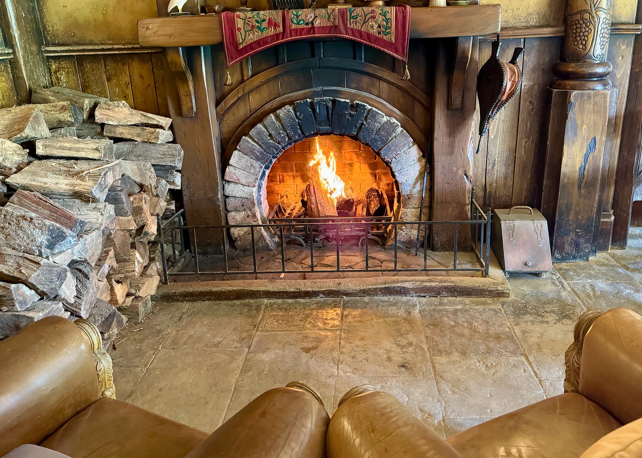 Glowing fireplace and comfortable chairs inside the green dragon.