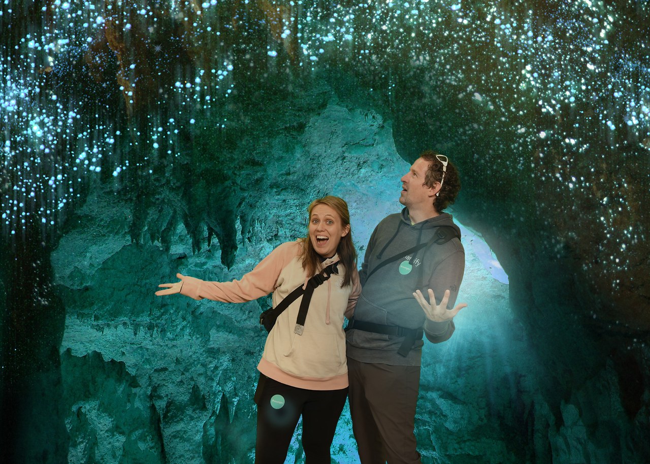 Mike and Stacy posed in a souvenir composite photograph beneath a simulated ceiling of Waitomo glowworms.