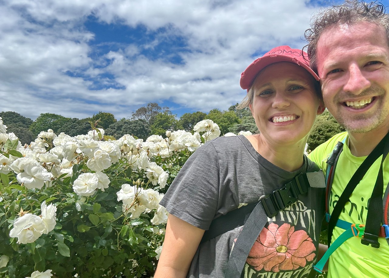 Mike and Stacy smiling near white roses in Wellington Botanic Garden.